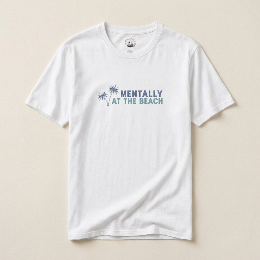 White t-shirt with 'Mentally at the Beach' text and palm tree graphics on a beige background